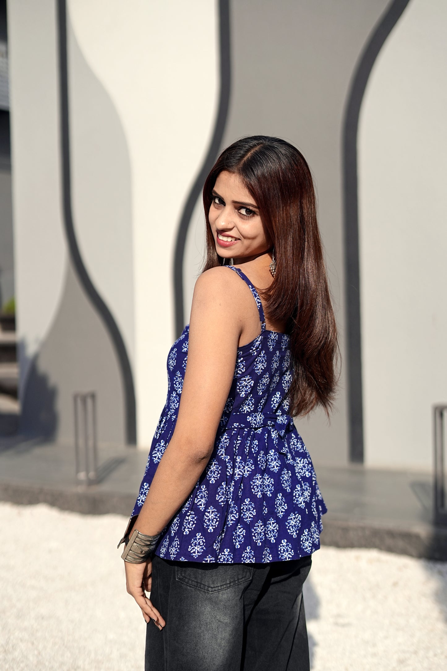 Woman wearing a blue floral top with a neutral background
